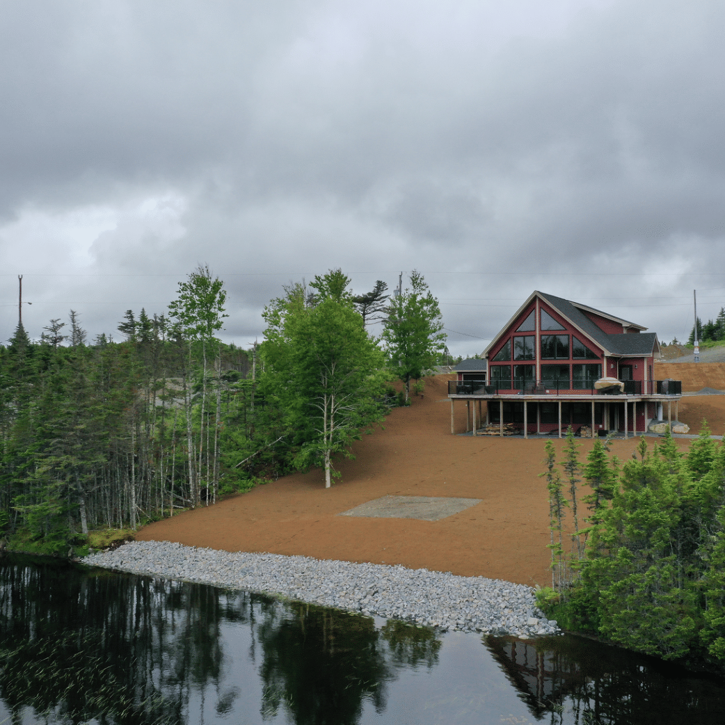 landscaping on a lawn with a pond on the edge with rocks